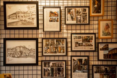 a wall with pictures of buildings on it at Spices Hotel in George Town