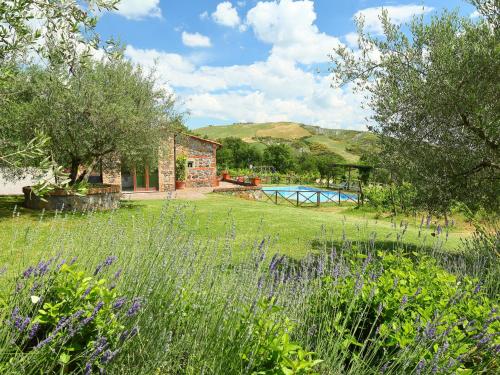 a garden with a stone house and a pool at Holiday Home Val d'Orcia by Interhome in Radicofani