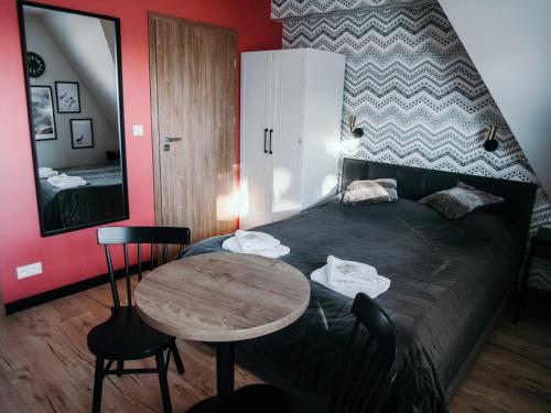 a bedroom with a bed with a table and a mirror at Willa Pachówka - tam, gdzie natura spotyka się z nowoczesnością in Bukowina Tatrzańska