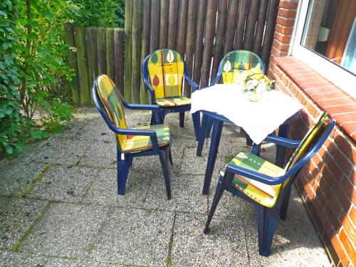 three chairs and a table with a childs toy at Holiday Home Koralle-1 by Interhome in Norddeich