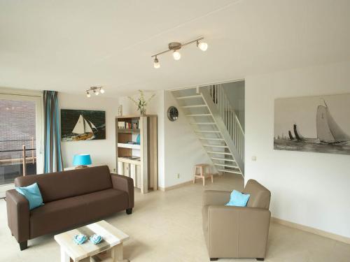 a living room with a couch and a chair at Villa Krekt Oer 't Wetter by Interhome in Uitwellingerga