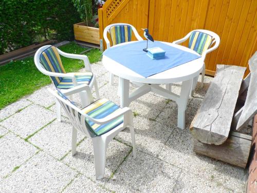 een witte tafel met vier stoelen en een kaars erop bij Holiday Home Müter by Interhome in Norddeich