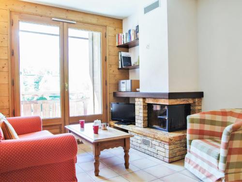 a living room with two chairs and a fireplace at Apartment Les Capucins by Interhome in Chamonix