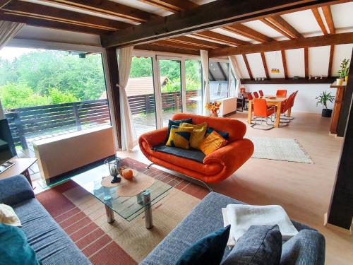 a living room with an orange couch and a table at Holiday Home Ferienpark Vorauf-4 by Interhome in Molberting