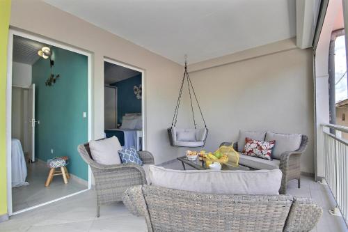a living room with wicker chairs and a table at Villa Perle Dor in Sainte-Anne