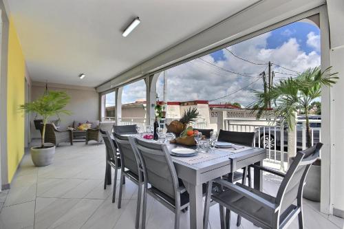 a dining room with a table and chairs on a balcony at Villa Perle Dor in Sainte-Anne