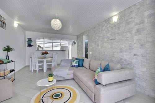 a living room with a couch and a table at Villa Perle Dor in Sainte-Anne
