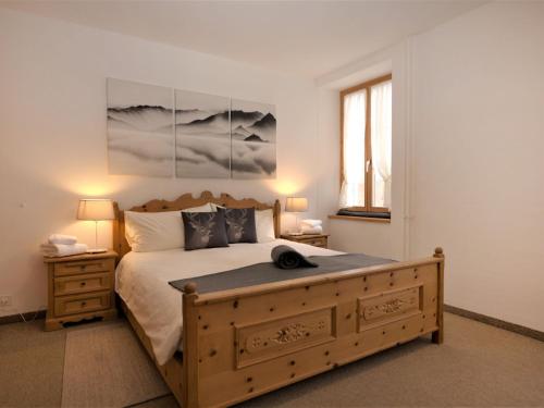 een slaapkamer met een groot bed met een houten frame bij Apartment Chesa Corvatsch by Interhome in Pontresina