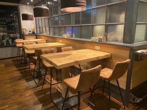 a bar with wooden tables and chairs in a restaurant at Heiner's Parkhotel in Gelsenkirchen