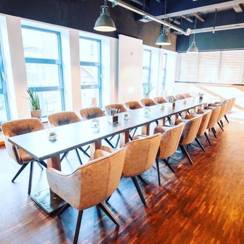 a long table and chairs in a room with windows at Heiner's Parkhotel in Gelsenkirchen
