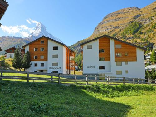 dos edificios en un campo con una montaña en el fondo en Studio Silence-4 by Interhome, en Zermatt