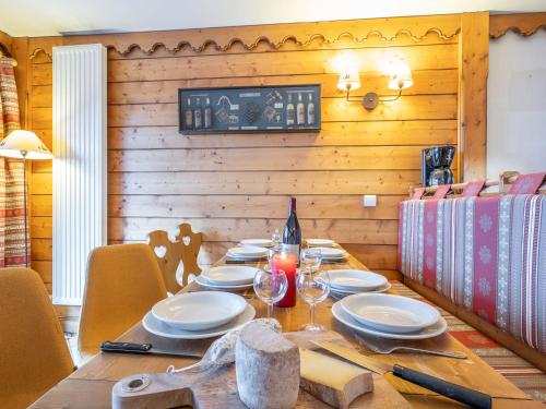 a wooden table with plates and wine glasses on it at Apartment Ecrin des Neiges - Val Claret-1 by Interhome in Tignes
