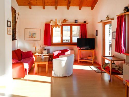 ein Wohnzimmer mit einem Sofa und einem TV in der Unterkunft Chalet Murena by Interhome in Schmitten