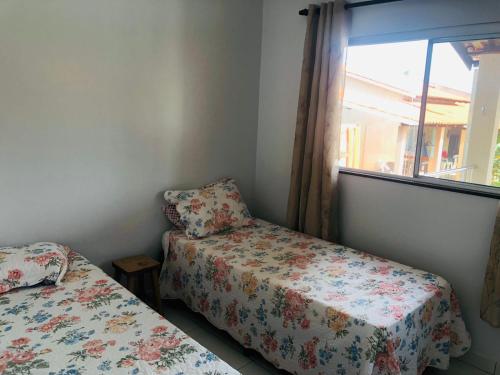 a bedroom with two beds and a window at Casa da Mari in Caldas Novas