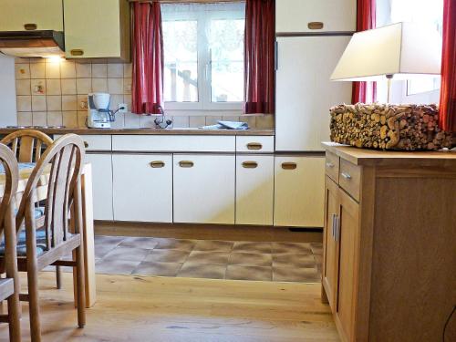 cocina con armarios blancos y mesa en Apartment Crap Milan by Interhome en Bivio