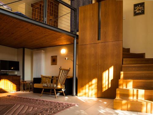 a living room with a staircase and a chair at Apartment Rosengarten by Interhome in Sterneck