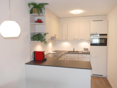 uma cozinha com armários brancos e um frigorífico branco em Apartment Allod-Park-30 by Interhome em Davos
