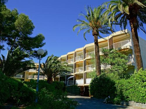 a building with palm trees in front of it at Studio Résidence Le Boréal-1 by Interhome in Saint-Raphaël