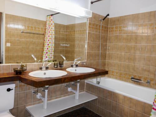 a bathroom with two sinks and a bath tub at Apartment Allod Park Haus C E03 by Interhome in Davos