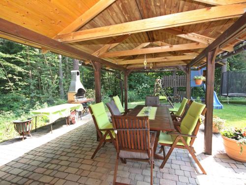 uma pérgola de madeira com uma mesa e cadeiras num pátio em Apartment Ogris-1 by Interhome em Selpritsch