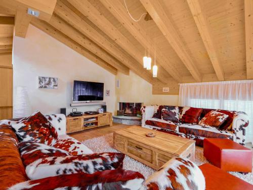 a living room with two couches and a tv at Apartment Rütschi-7 by Interhome in Zermatt