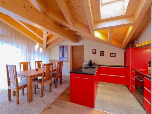 ツェルマットにあるApartment Rütschi-7 by Interhomeのキッチン(赤いキャビネット、テーブル、椅子付)