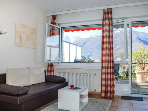 ein Wohnzimmer mit einem Sofa und 2 Fenstern in der Unterkunft Apartment Corallo - Utoring-25 by Interhome in Ascona