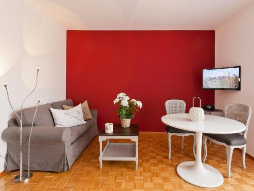 a living room with a red wall and a couch and a table at Apartment Double Room-2 by Interhome in Ascona