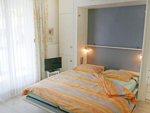 a bedroom with a large bed and a television at Apartment Corallo - Utoring-1 by Interhome in Ascona