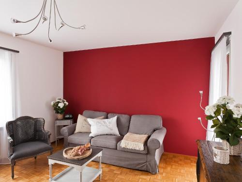 - un salon avec un canapé et un mur rouge dans l'établissement Apartment Suite-18 by Interhome, à Ascona
