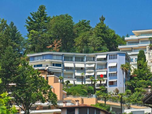 an apartment building on a hill with trees at Apartment Double Room Modern-2 by Interhome in Ascona