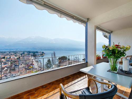 a balcony with a table and chairs and a large window at Apartment Suite Classic-14 by Interhome in Ascona