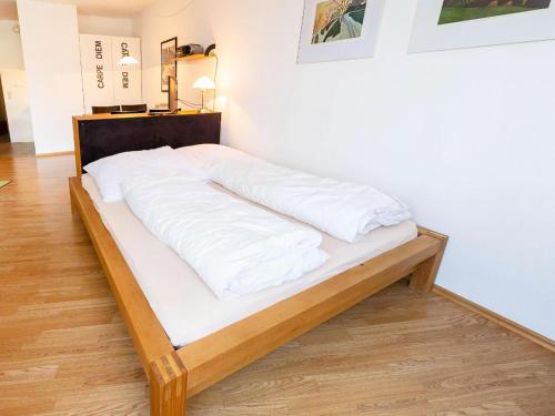 un letto con lenzuola bianche sopra in una stanza di Apartment Ferienwohnpark Immenstaad-3 by Interhome a Immenstaad am Bodensee