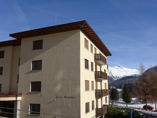 a building with a snow covered mountain in the background at Apartment Chesa Romantica 17 by Interhome in St. Moritz