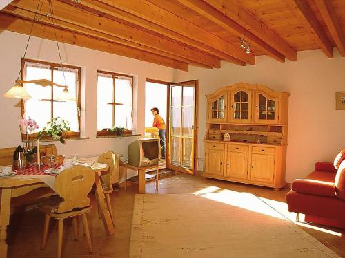 un soggiorno con tavolo e una persona in cucina di Apartment Biohof Herrenweg-1 by Interhome a Dreimühlen