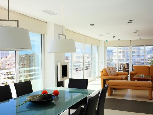 ein Wohnzimmer mit einem Glastisch und Stühlen in der Unterkunft Apartment Esmeralda-1 by Interhome in Calpe
