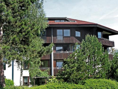 a large building with a balcony and trees at Apartment Ferienwohnpark Immenstaad-1 by Interhome in Immenstaad am Bodensee