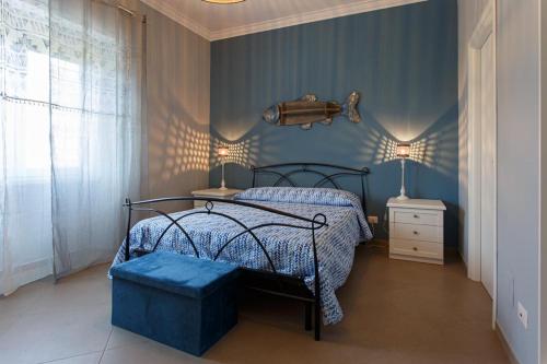 a bedroom with a bed with a blue comforter at Alloggi Villa Sarsina in Anzio