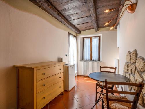 uma cozinha com uma mesa e uma pequena mesa e cadeiras em Apartment Mansarda by Interhome em Orta San Giulio