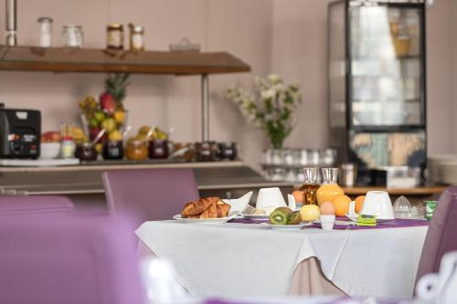 a table with plates of food on it at Hôtel Spa Thermalia in Châtel-Guyon