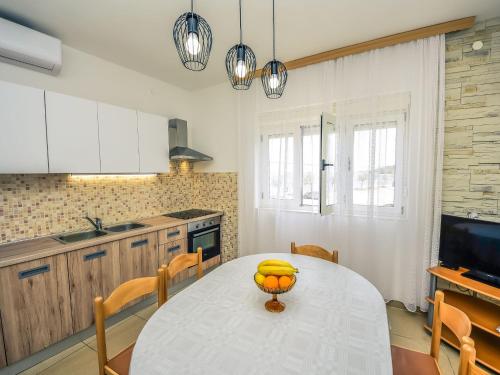 eine Küche mit einem Tisch und einer Schüssel Orangen darauf in der Unterkunft Holiday Home Ankica by Interhome in Pašman