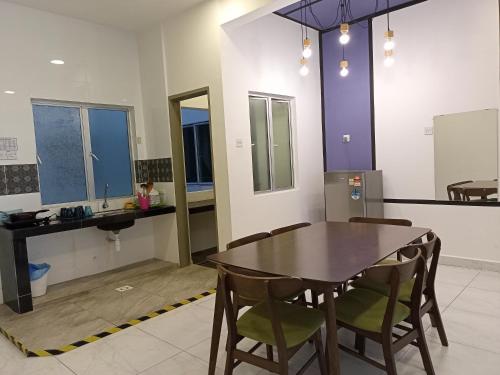 a dining room with a table and chairs and a sink at Cameron Homestay @ Quintet in Tanah Rata