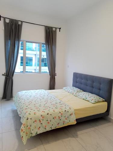 a bed with a blue headboard in a room with a window at Cameron Homestay @ Quintet in Tanah Rata