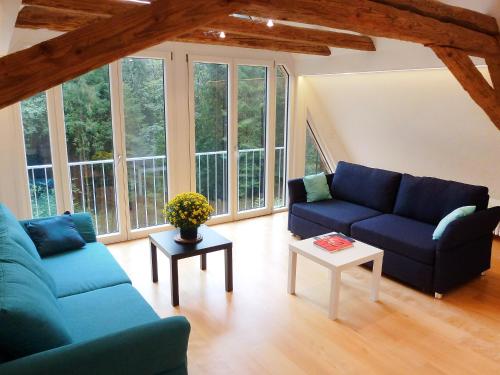 una sala de estar con 2 sofás azules y una mesa. en Holiday Home Leubach by Interhome en Schiltach