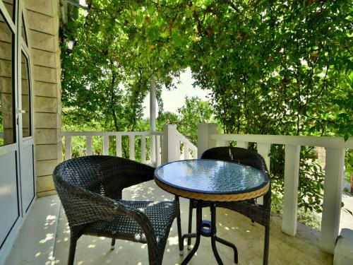 two chairs and a table on a porch at Holiday Home Moreška-2 by Interhome in Viganj