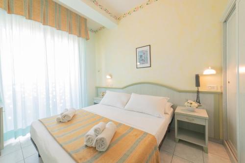 een slaapkamer met een bed met handdoeken erop bij Hotel Cavalli in Cattolica