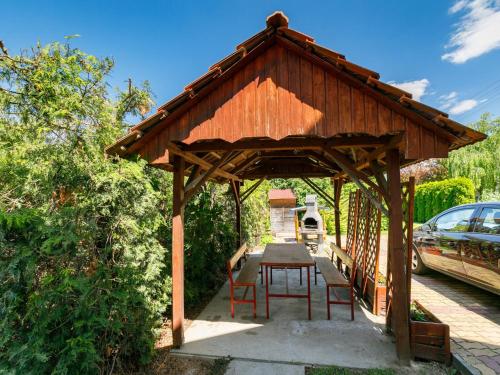 a wooden gazebo with a picnic table in it at Apartment Scarlett 1 by Interhome in Balatonszemes