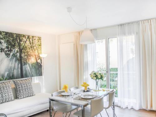 a white living room with a table and a white couch at Apartment Residenza Corallo-16 by Interhome in Ascona