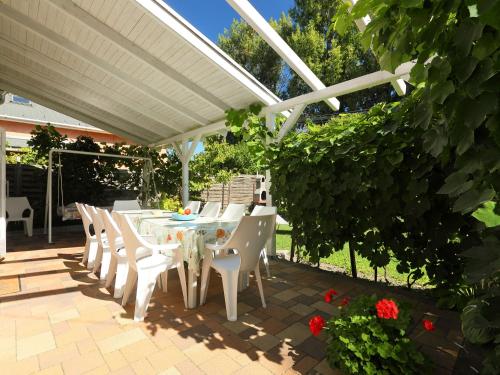 a white table and chairs under a white pergola at Holiday Home Mandorle by Interhome in Balatonboglár