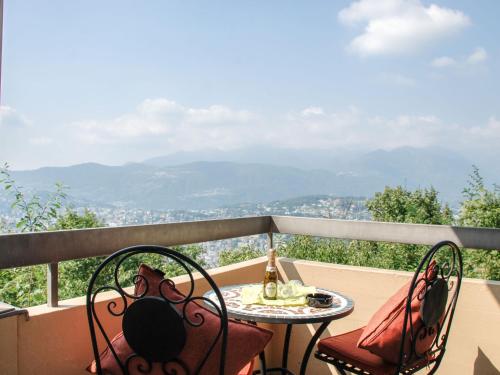 a table and chairs on a balcony with a view at Apartment Residenza Monte Bré - Apt-004 Haus1 by Interhome in Lugano